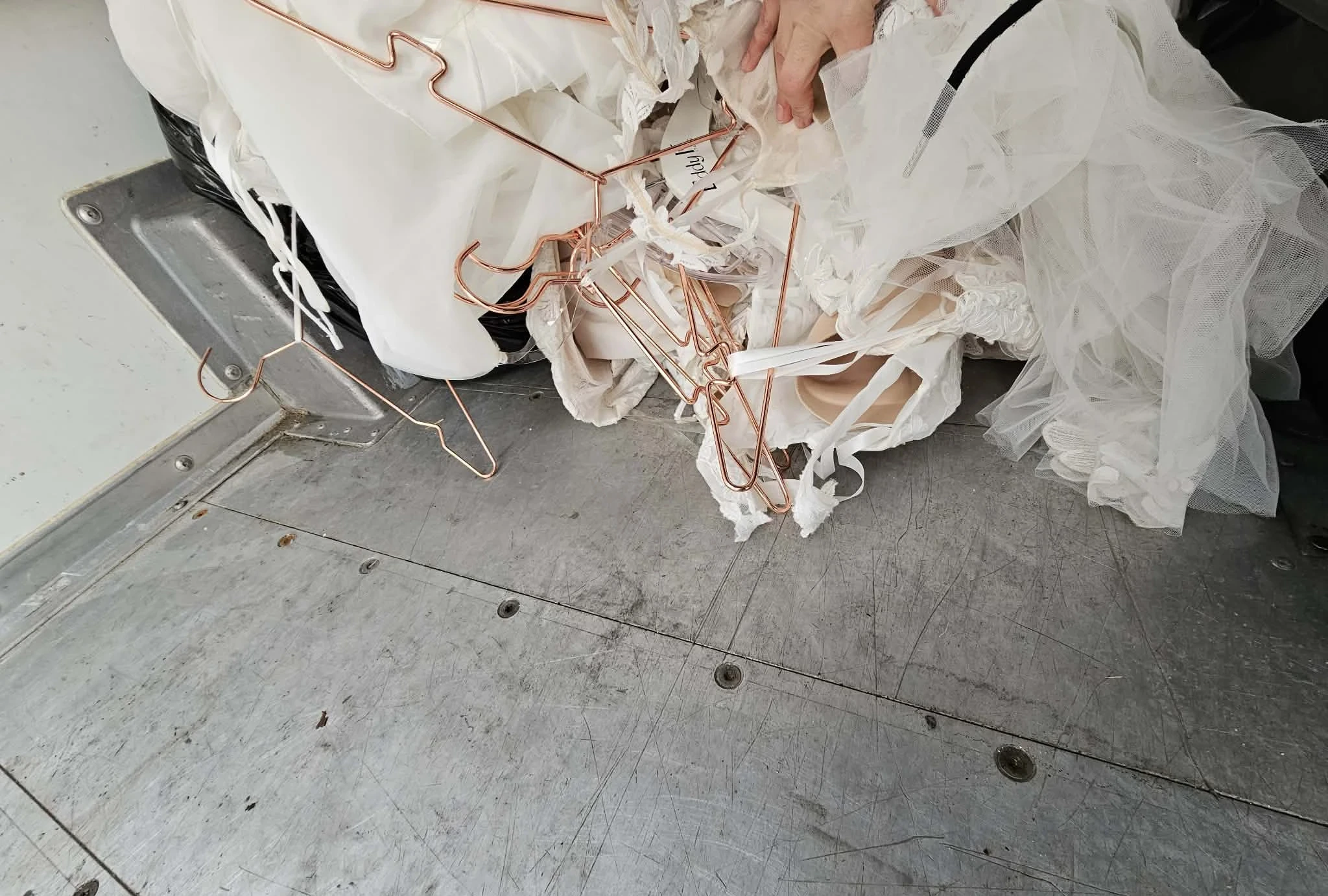 Hangers tangled with gown fabric on truck floor