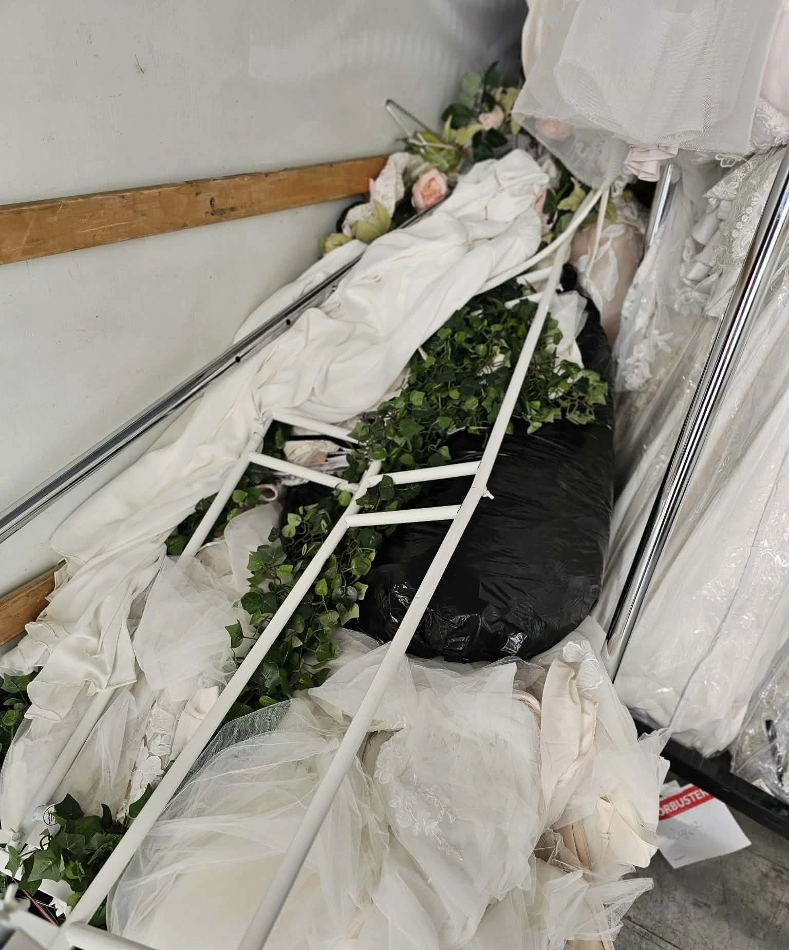 Collapsed backdrop frame tangled with gowns